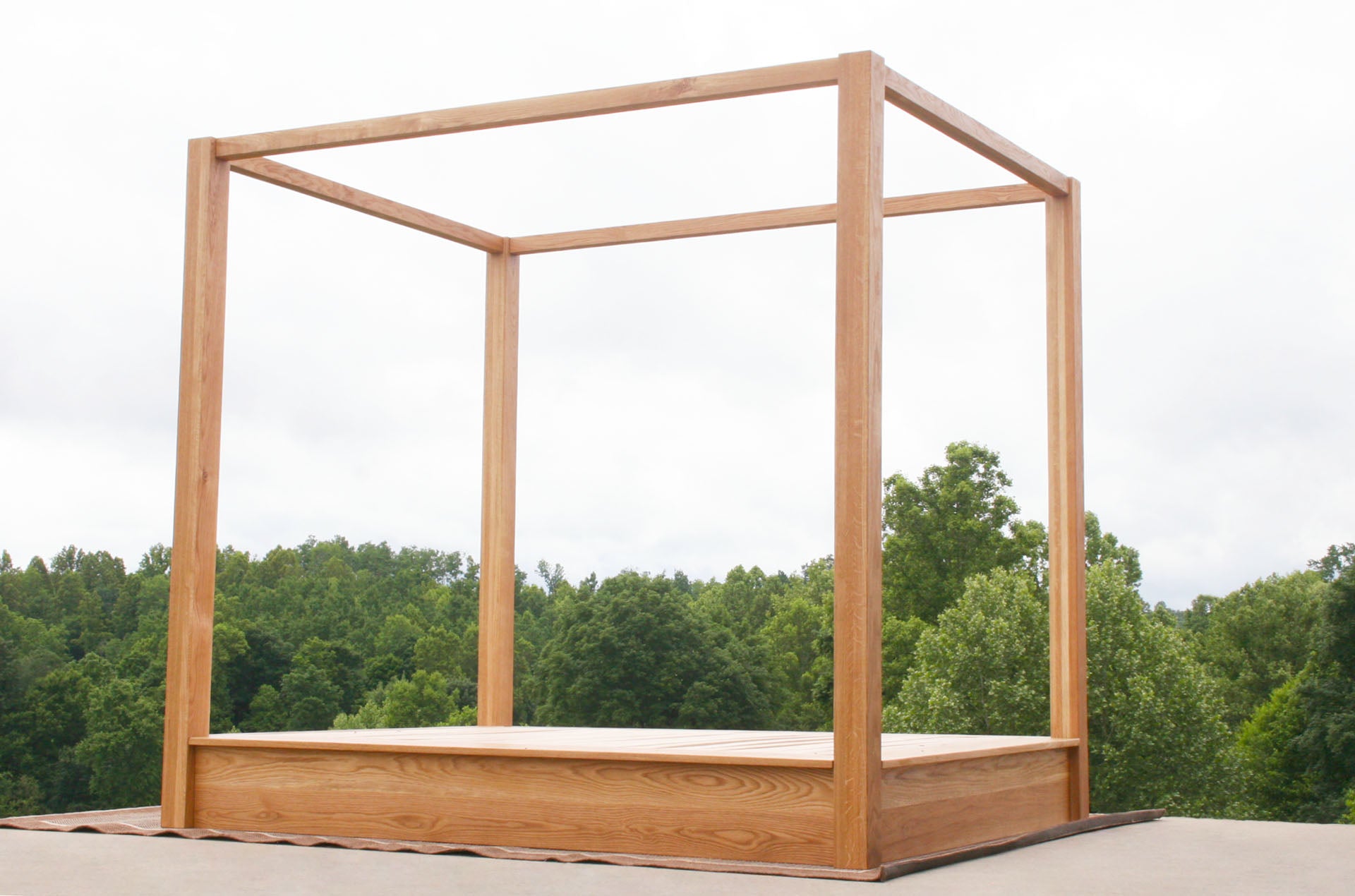 low angled view wood Low Platform Bed with large posts and canopy