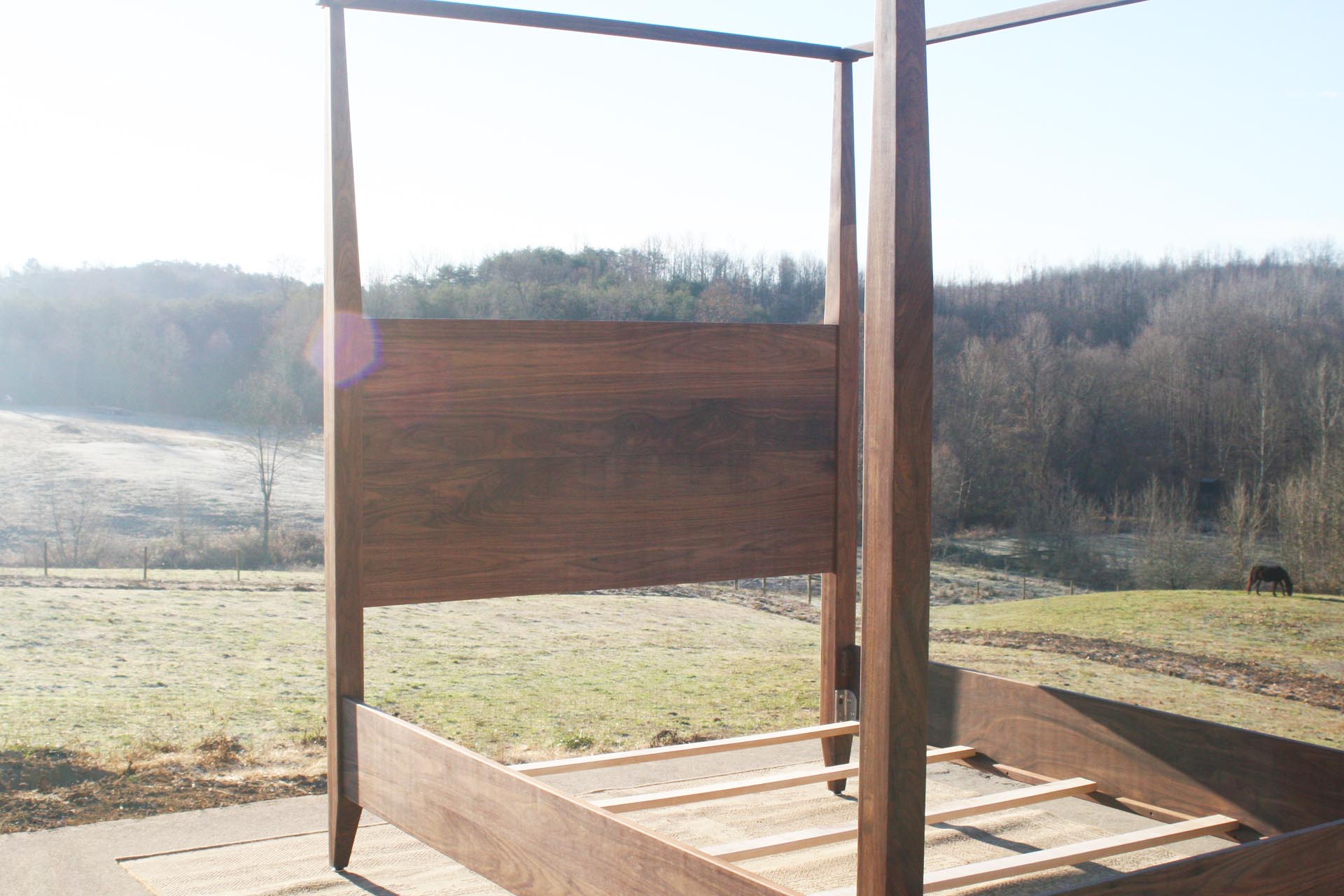 walnut wood canopy bed with tapered posts and headboard close view