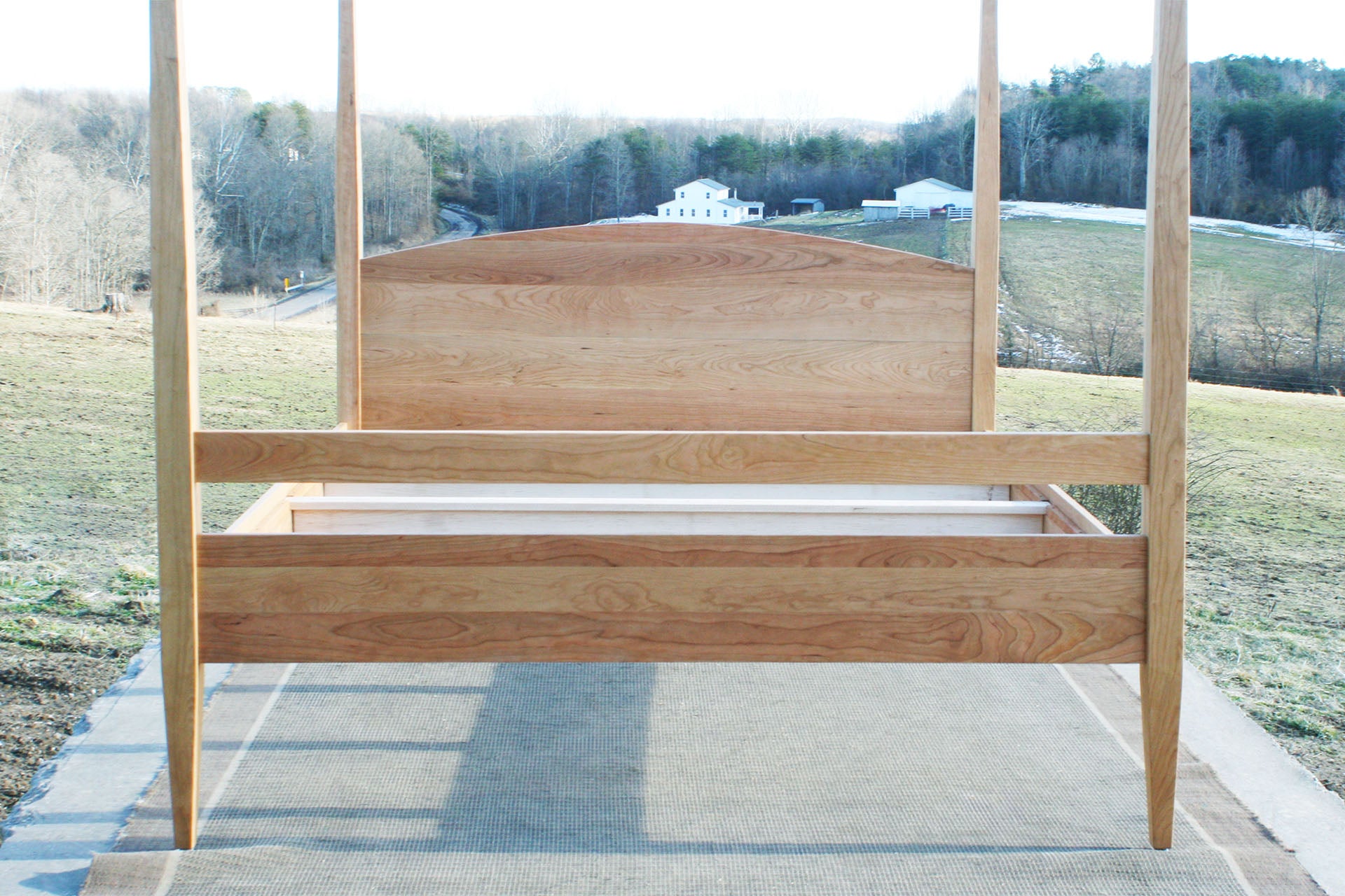 end of natural canopy bed with tall legs 