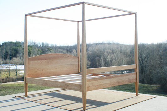natural canopy bed with tall legs angled view
