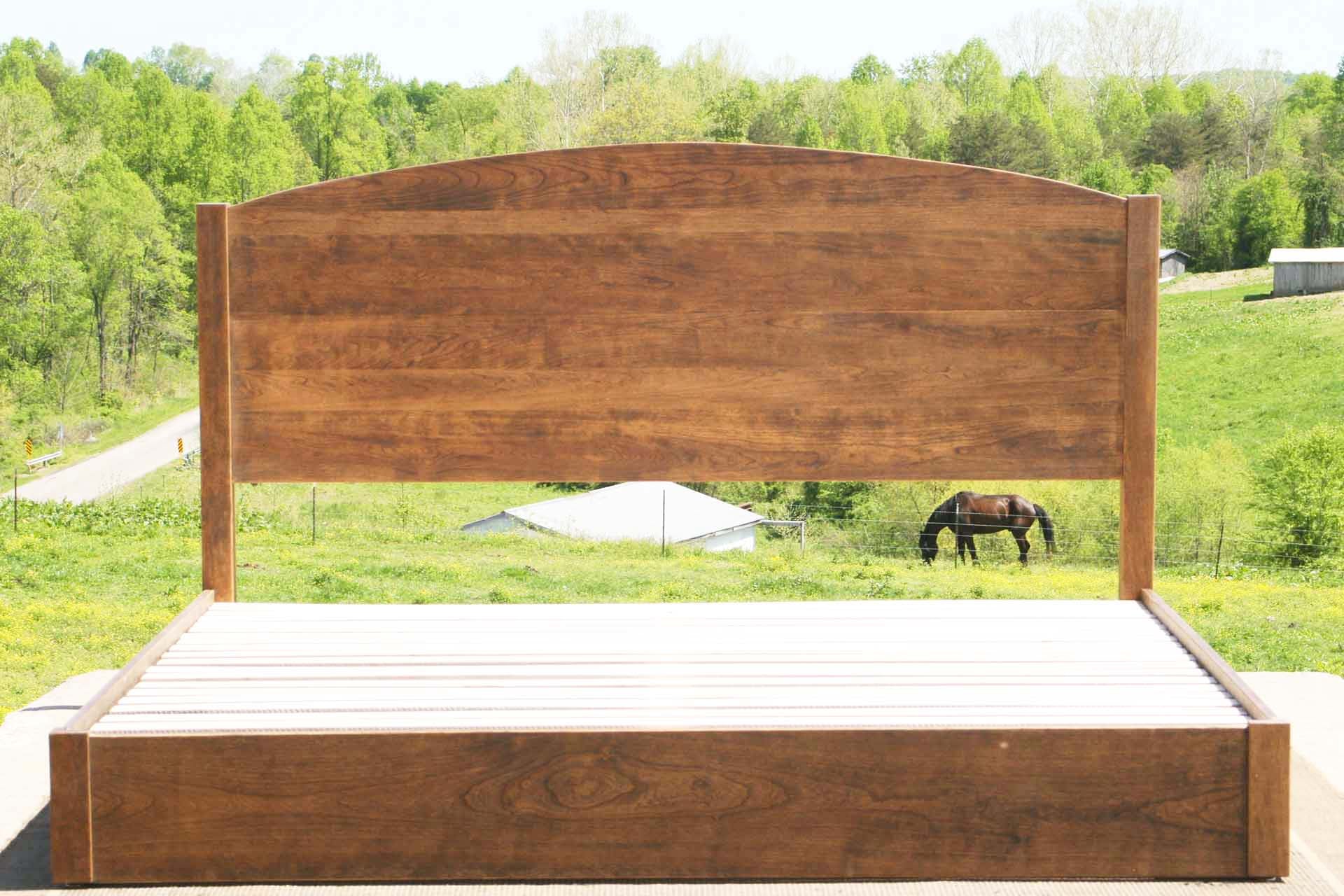 low platform bed with arched headboard front view