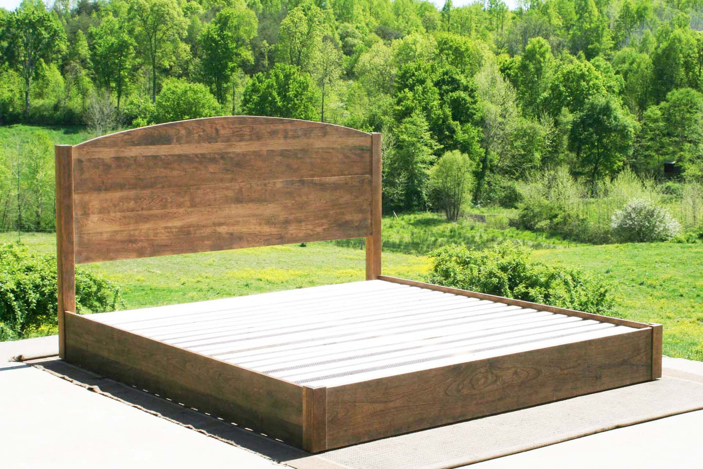 low platform bed with arched headboard side angled view