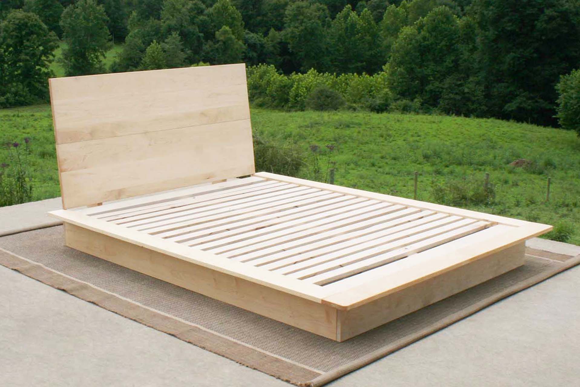 front angled view natural Platform Bed with large headboard and wide platform extensions light colored