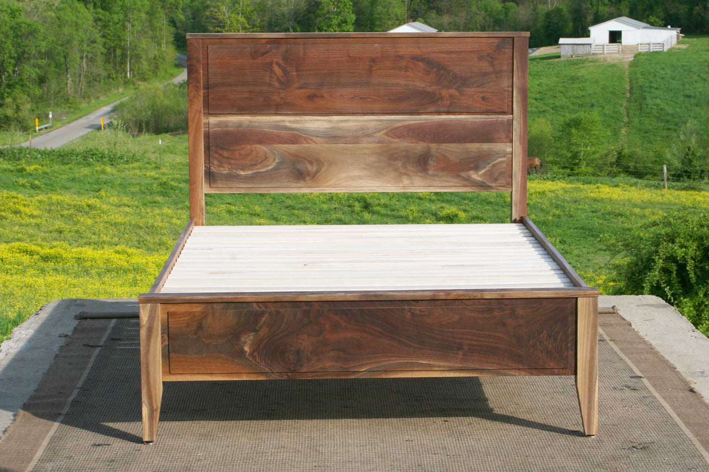 Paneled bed with platform and raised headboard front view