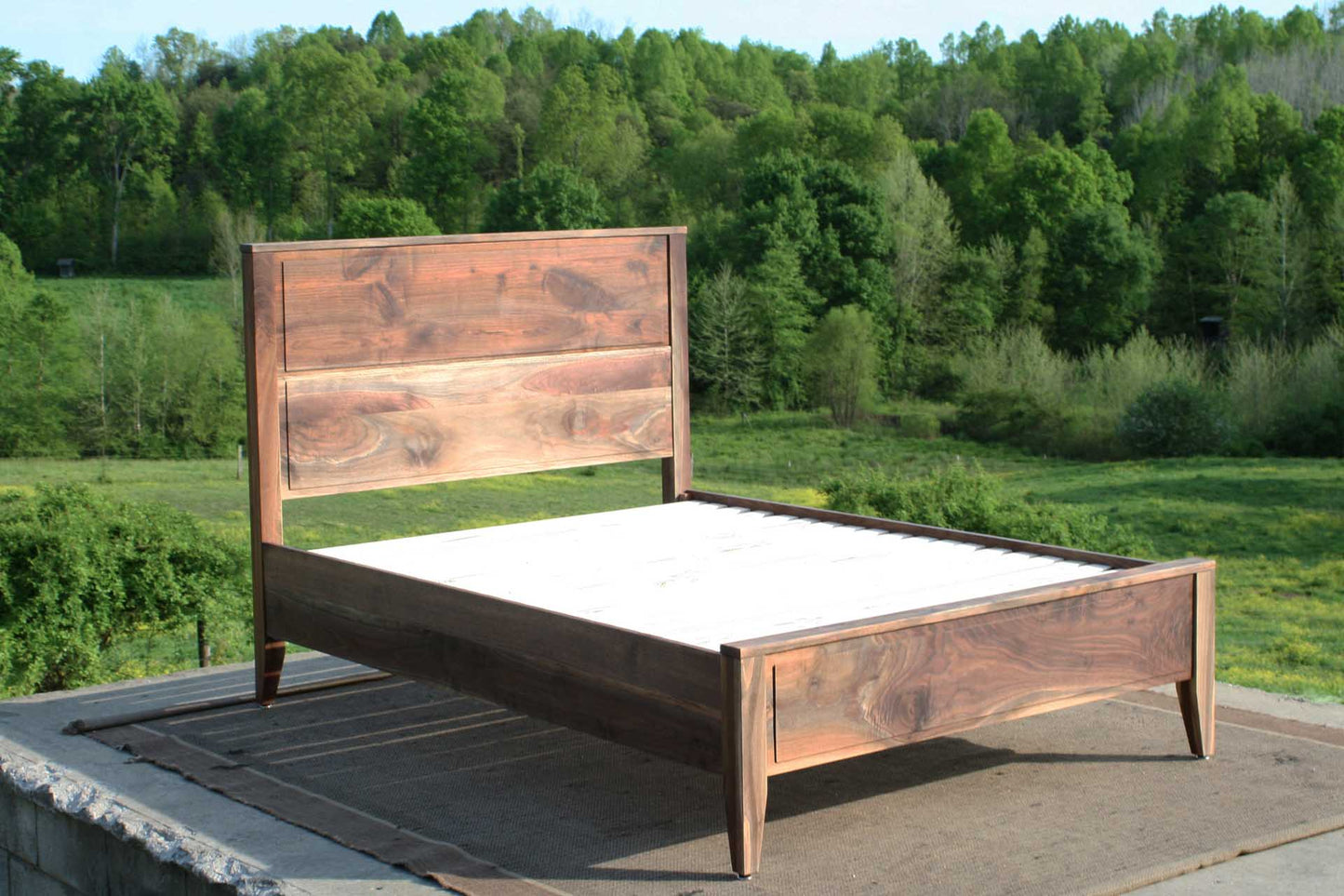 Paneled bed with platform and raised headboard angled side view
