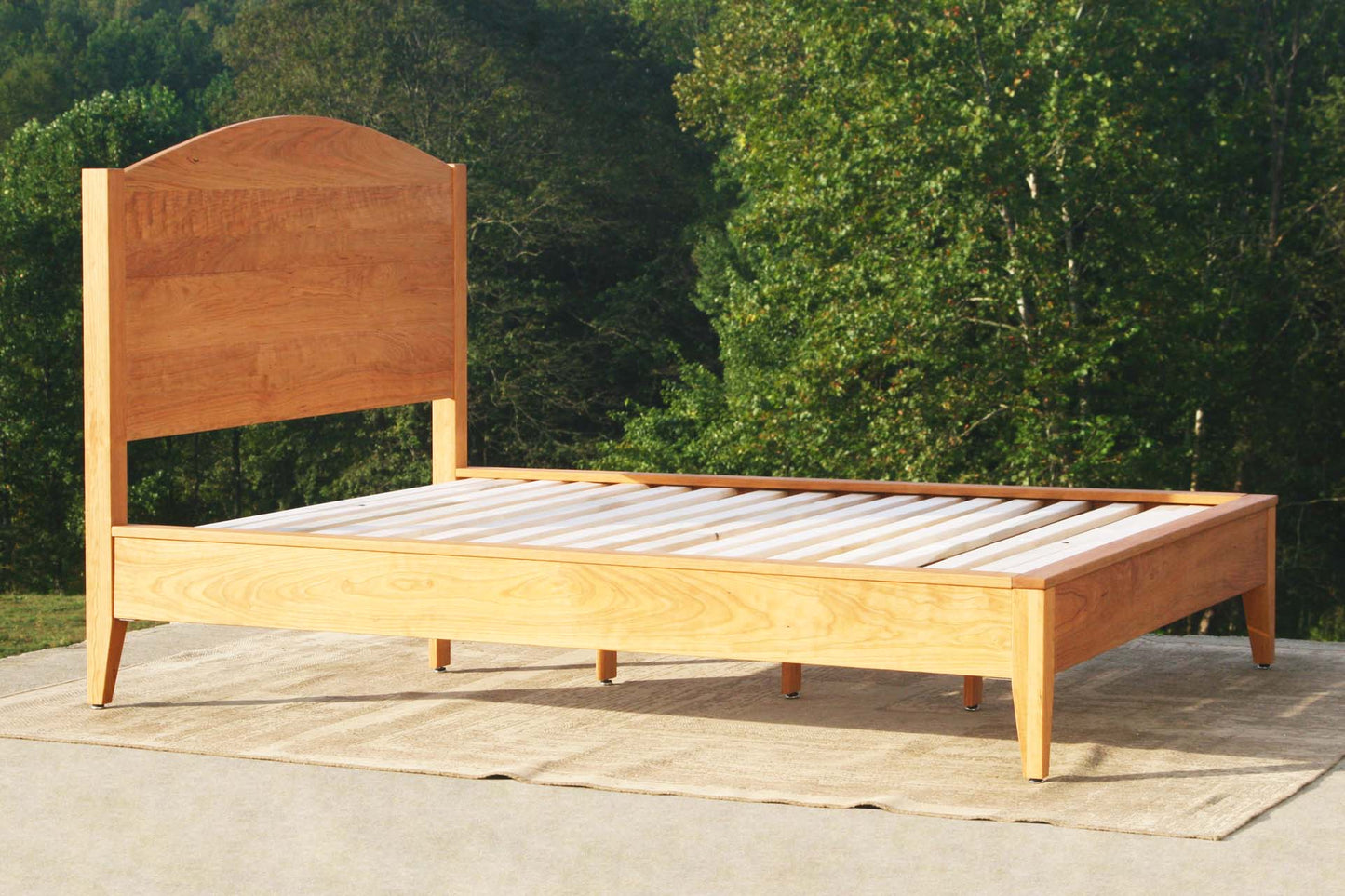 angled view natural Platform bed with curved headboard