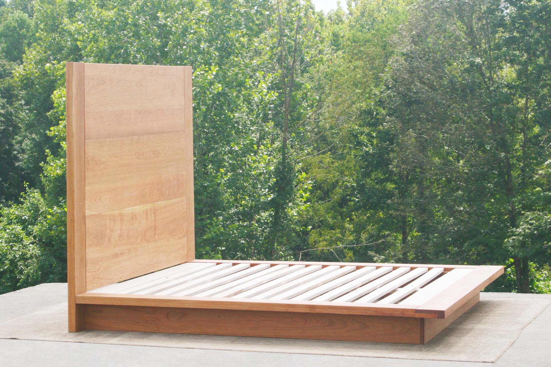 side angled view natural Platform bed with tall headboard