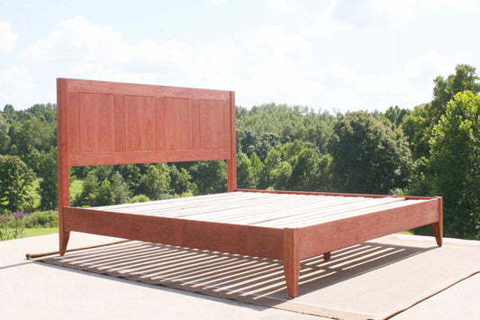 angled view low profile platform Bed with paneled headboard and tapered posts