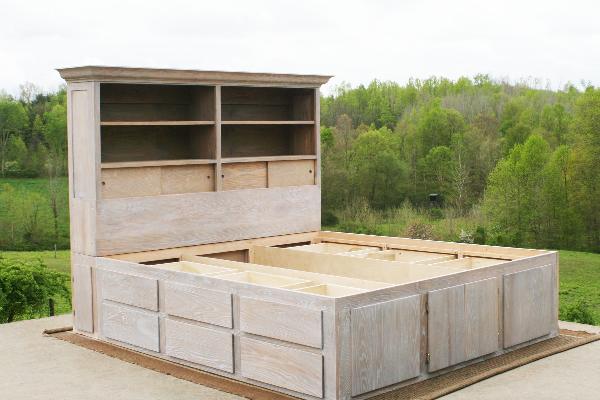 angled view of wood 12 drawer captain's bed with storage headboard