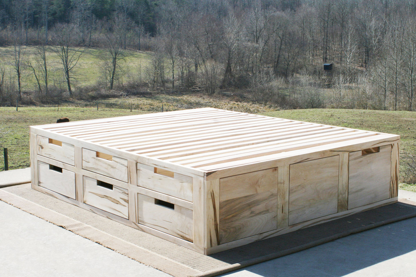 angled view natural wood Mates bed with 6 drawers on 1 side