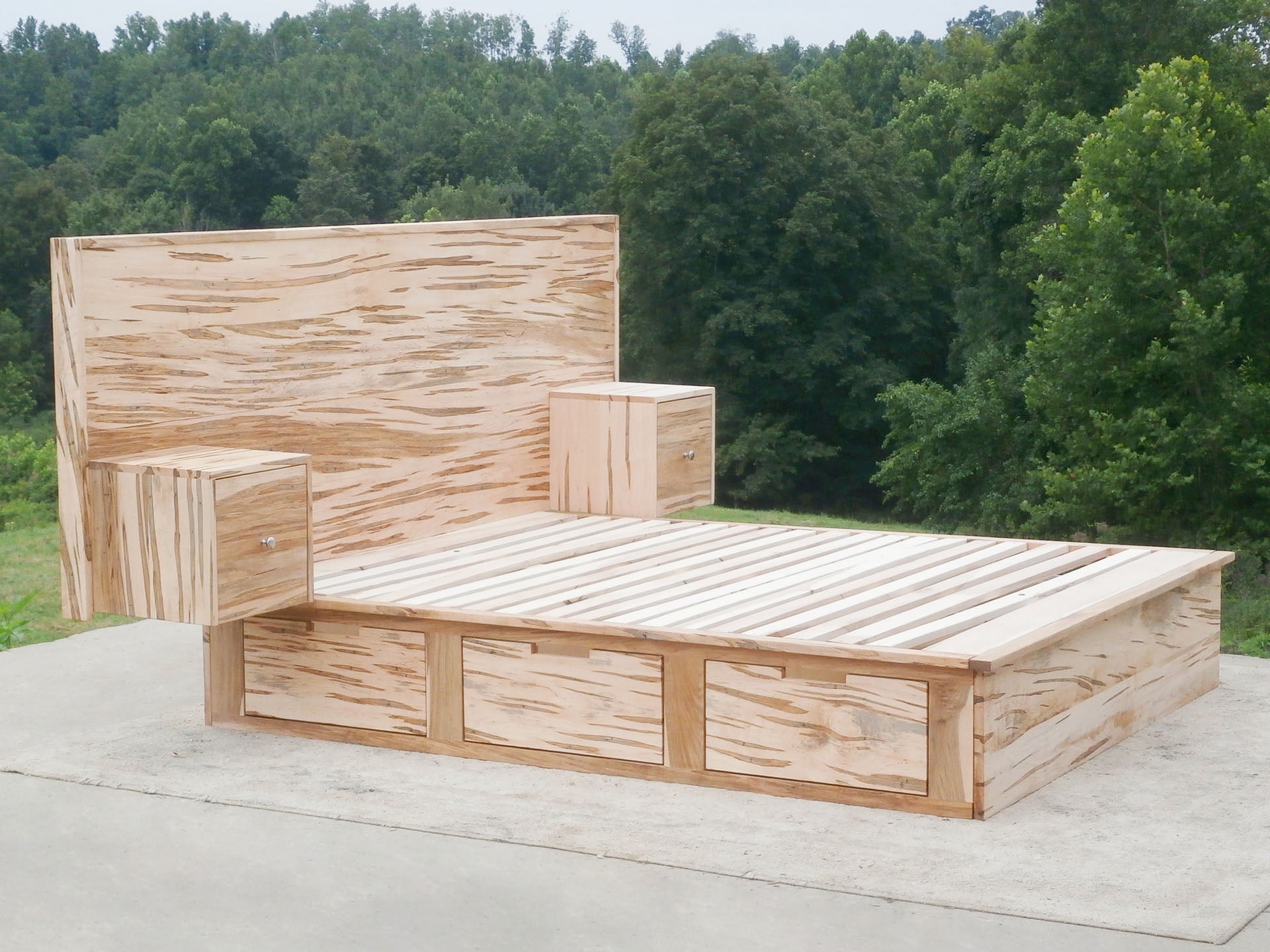 side angled view natural 6 drawer storage bed with built-in nightstands