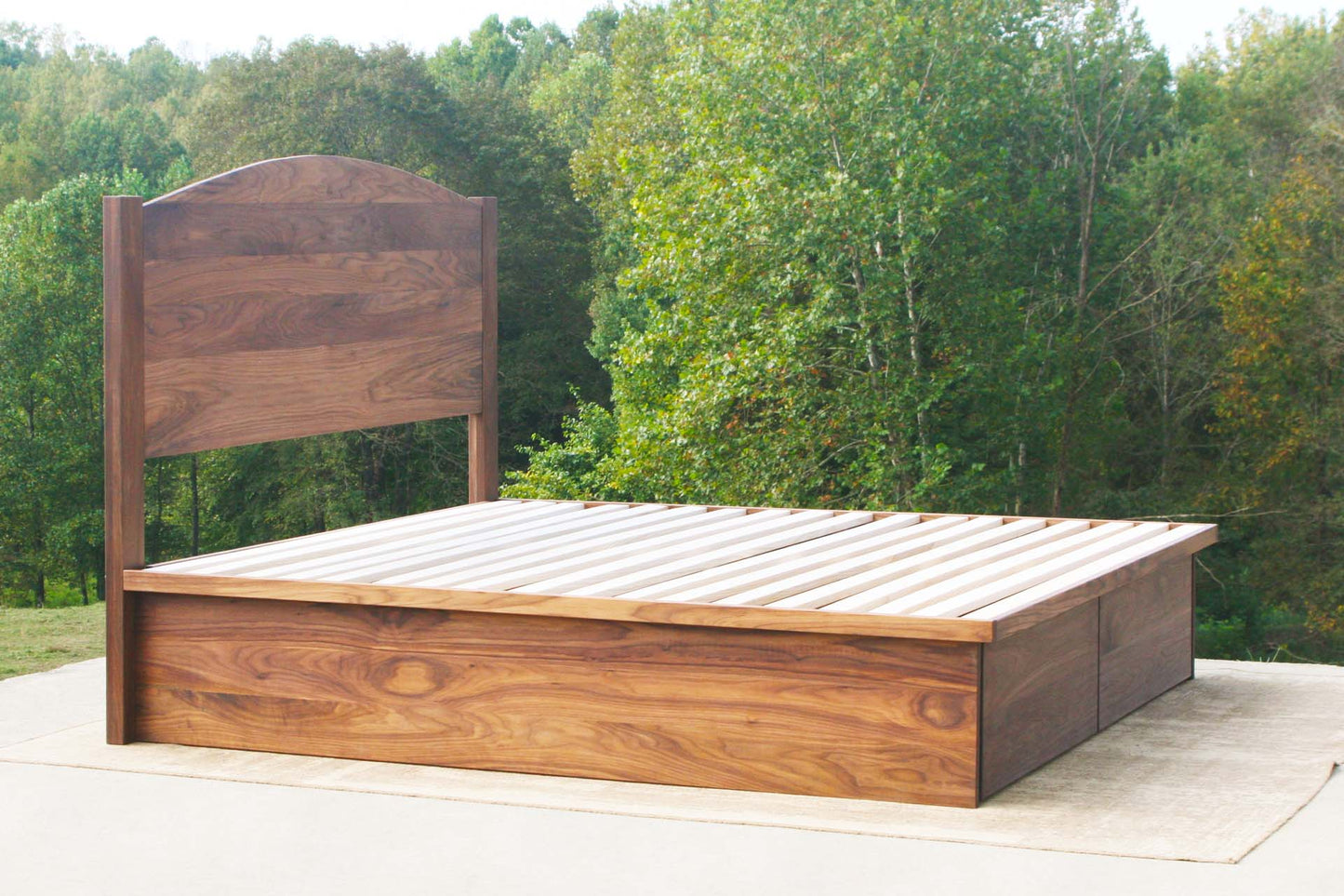 angled view custom Platform bed with 4 drawers and headboard with top bar