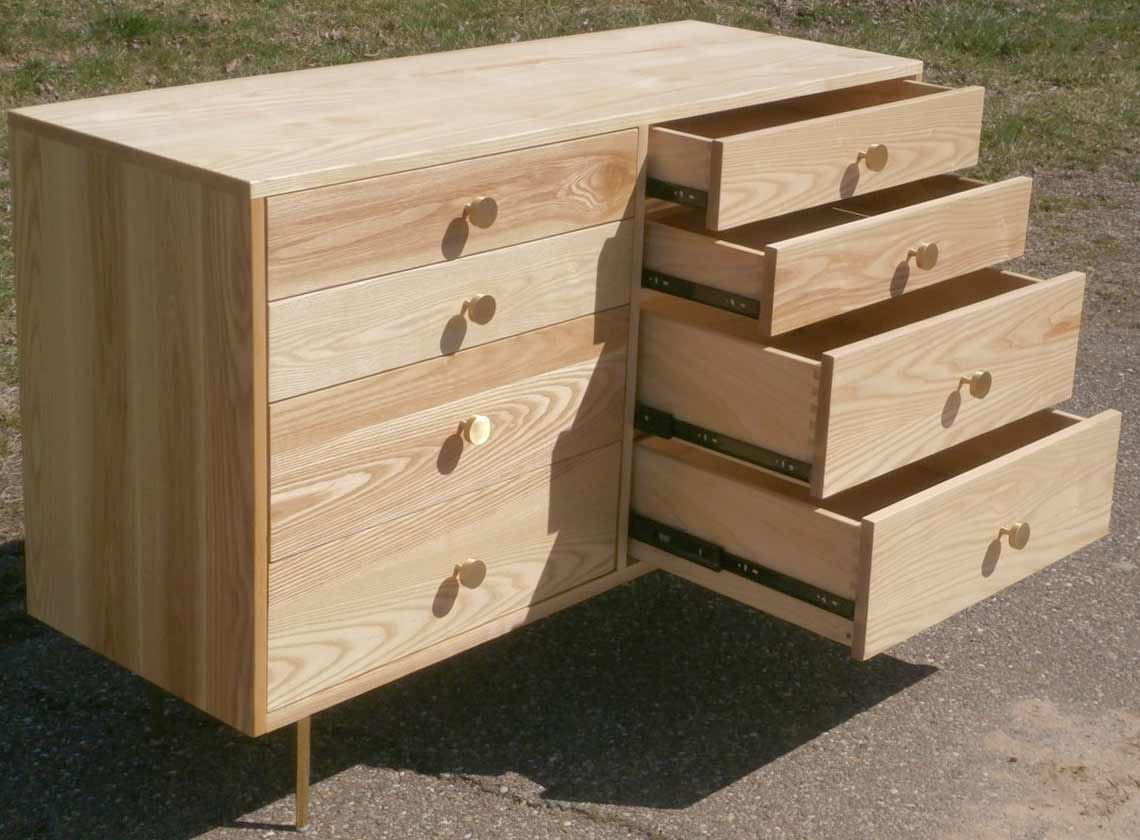 top angled view drawers out dresser with 8 inset drawers and mid century modern polished brass legs and drawer pulls