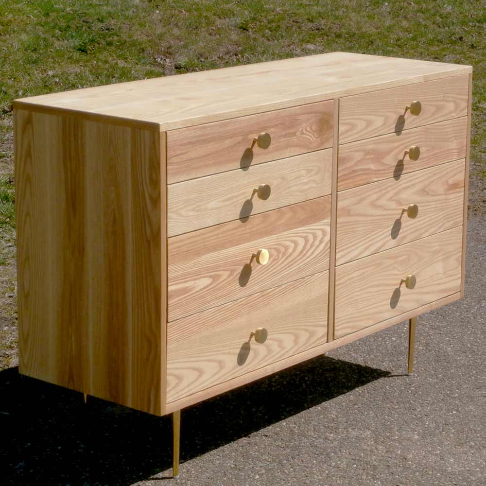 angled view dresser with 8 inset drawers and mid century modern polished brass legs and drawer pulls