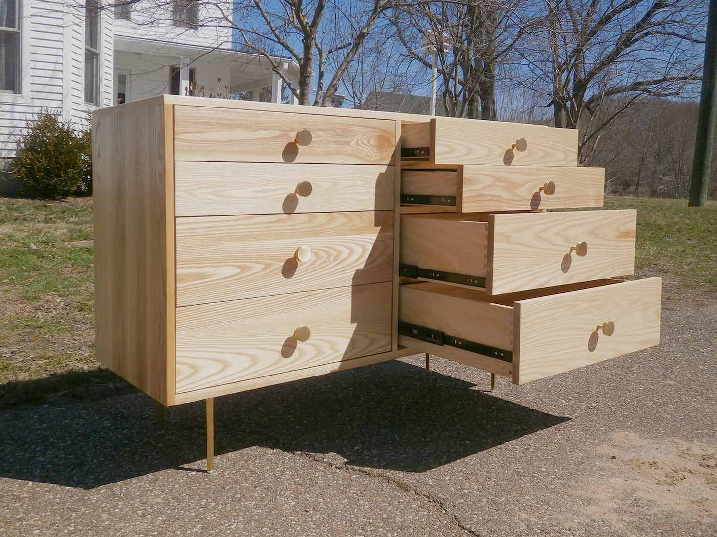 angled view drawers open dresser with 8 inset drawers and mid century modern polished brass legs and drawer pulls