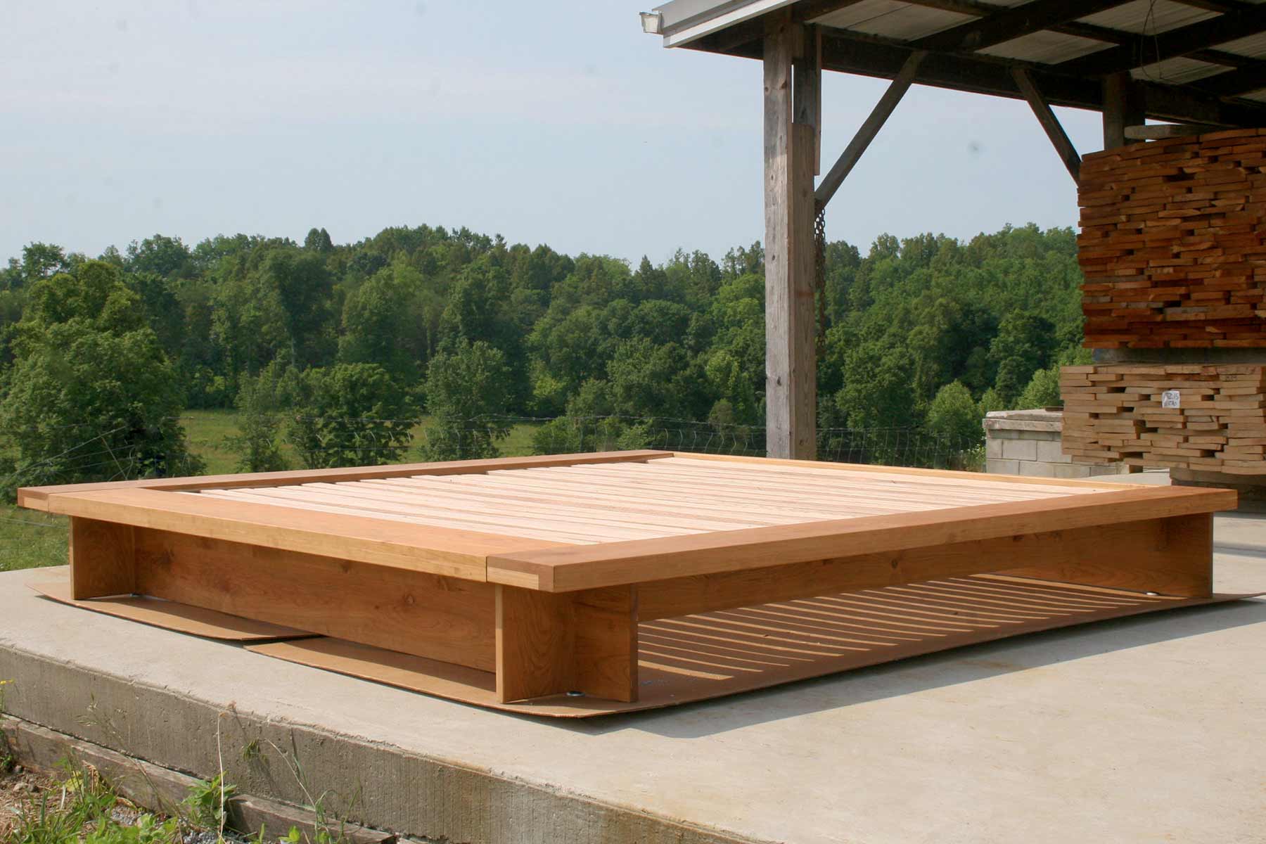 angled view hardwood low platform bed with wide platform and optional side tables