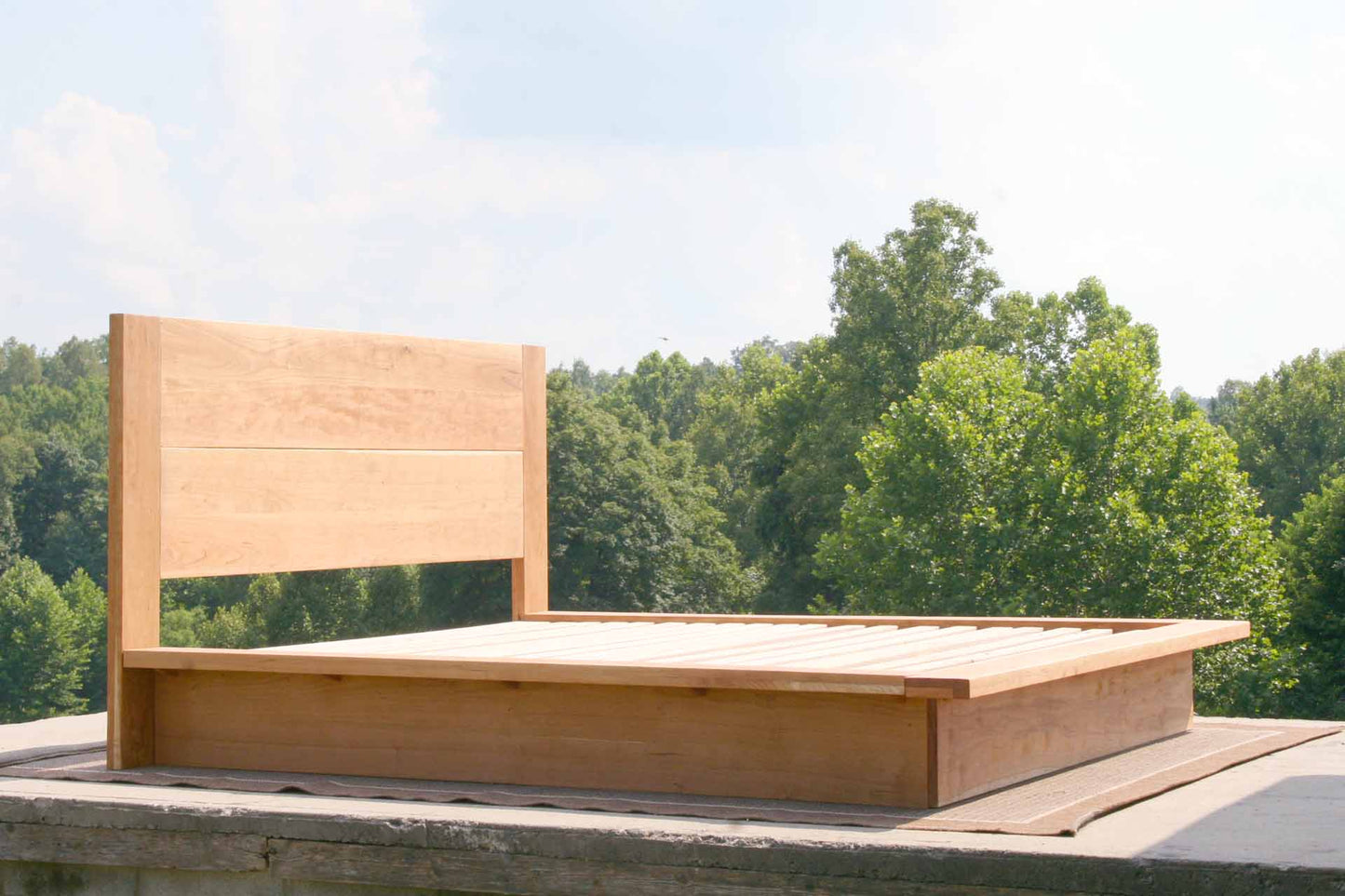 Platform bed with tall headboard and wide sides angled view