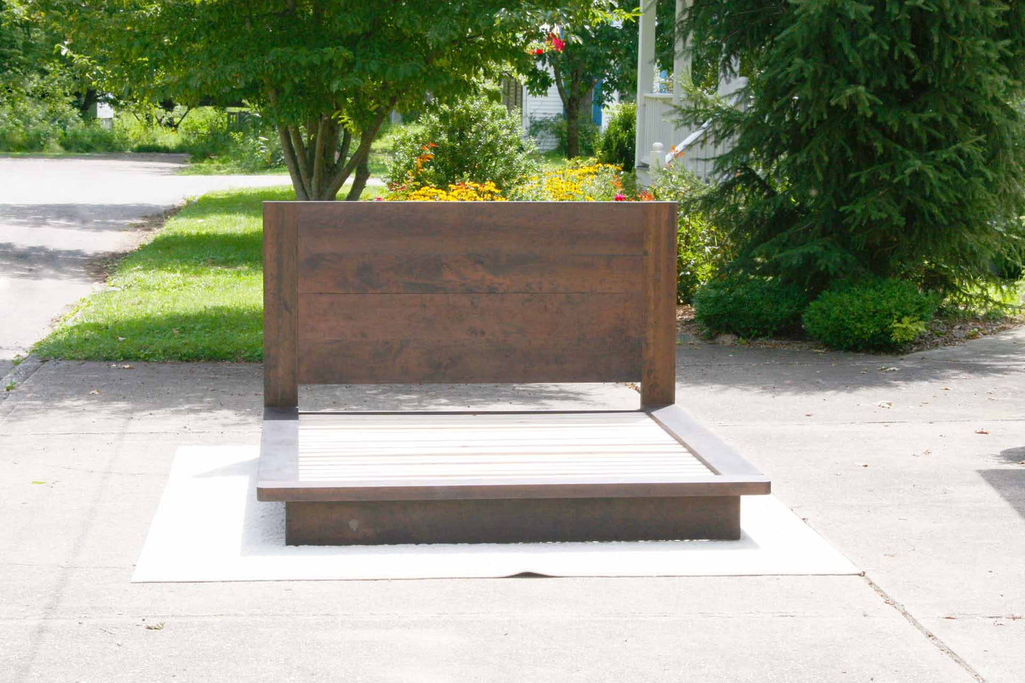 Platform bed with tall headboard and wide sides in walnut