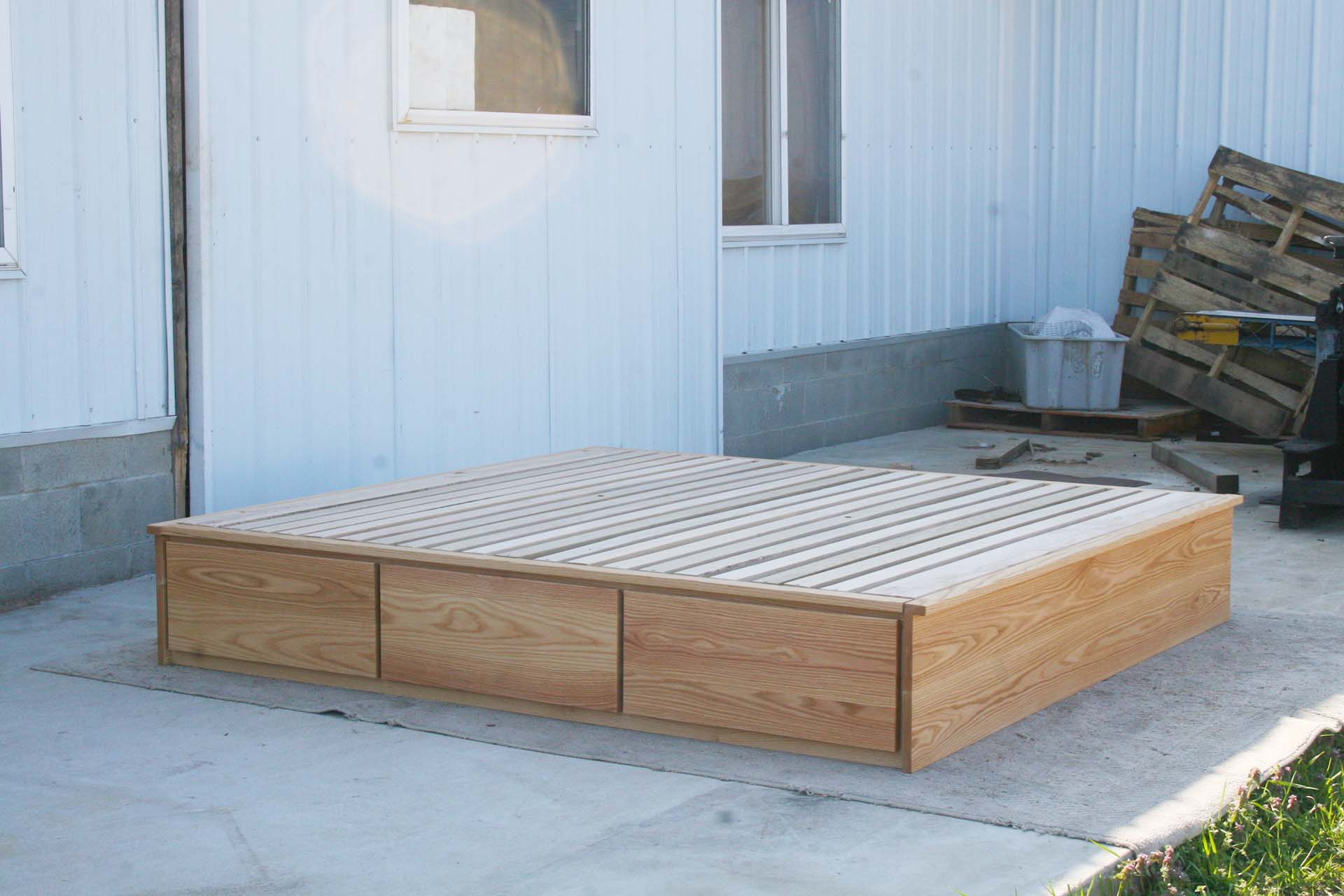 angled view low storage bed with 6 drawers that has optional side tables