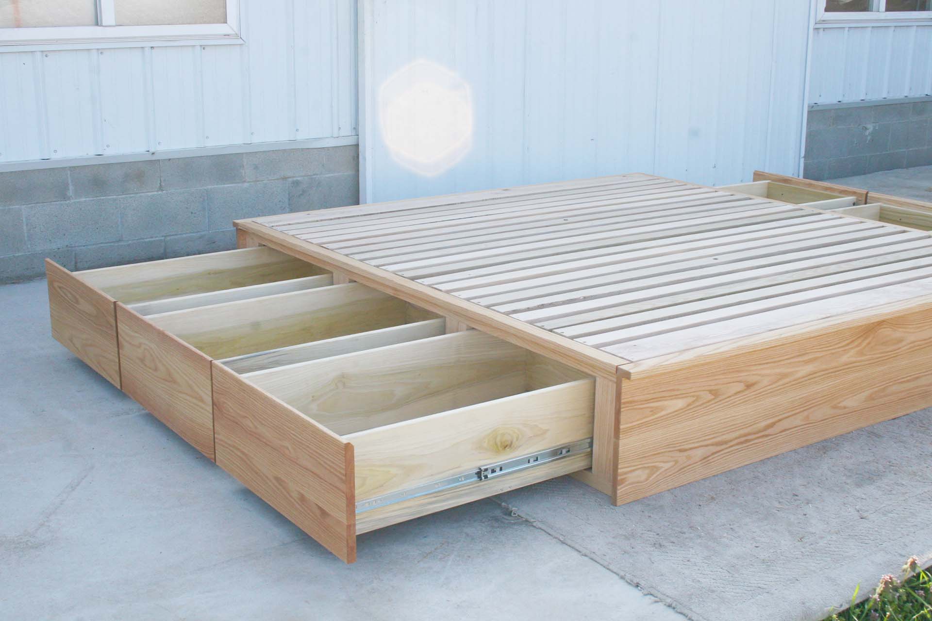 low storage bed with 6 drawers that has optional side tables angled view drawers open