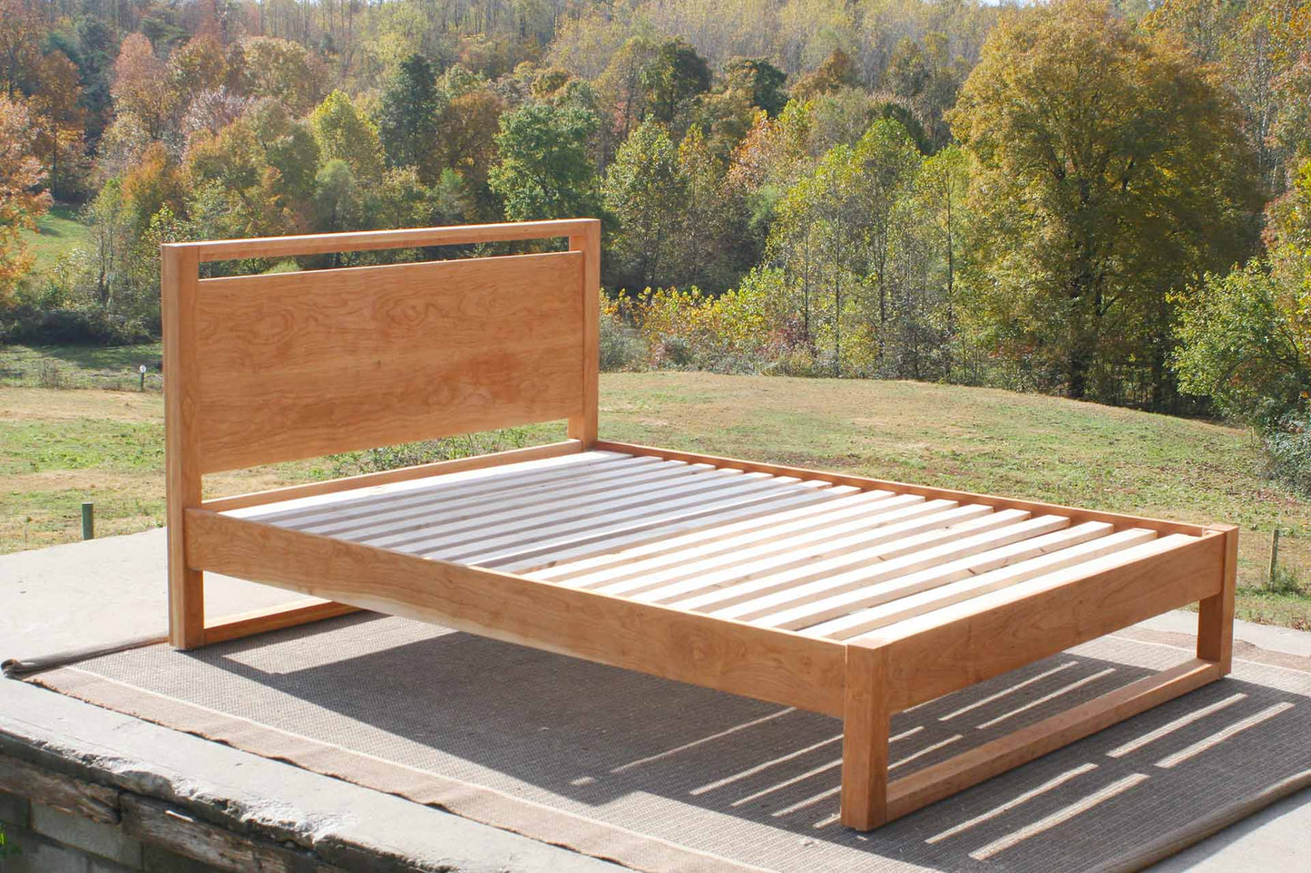 platform bed with a rail above the head board and rails at floor angled view