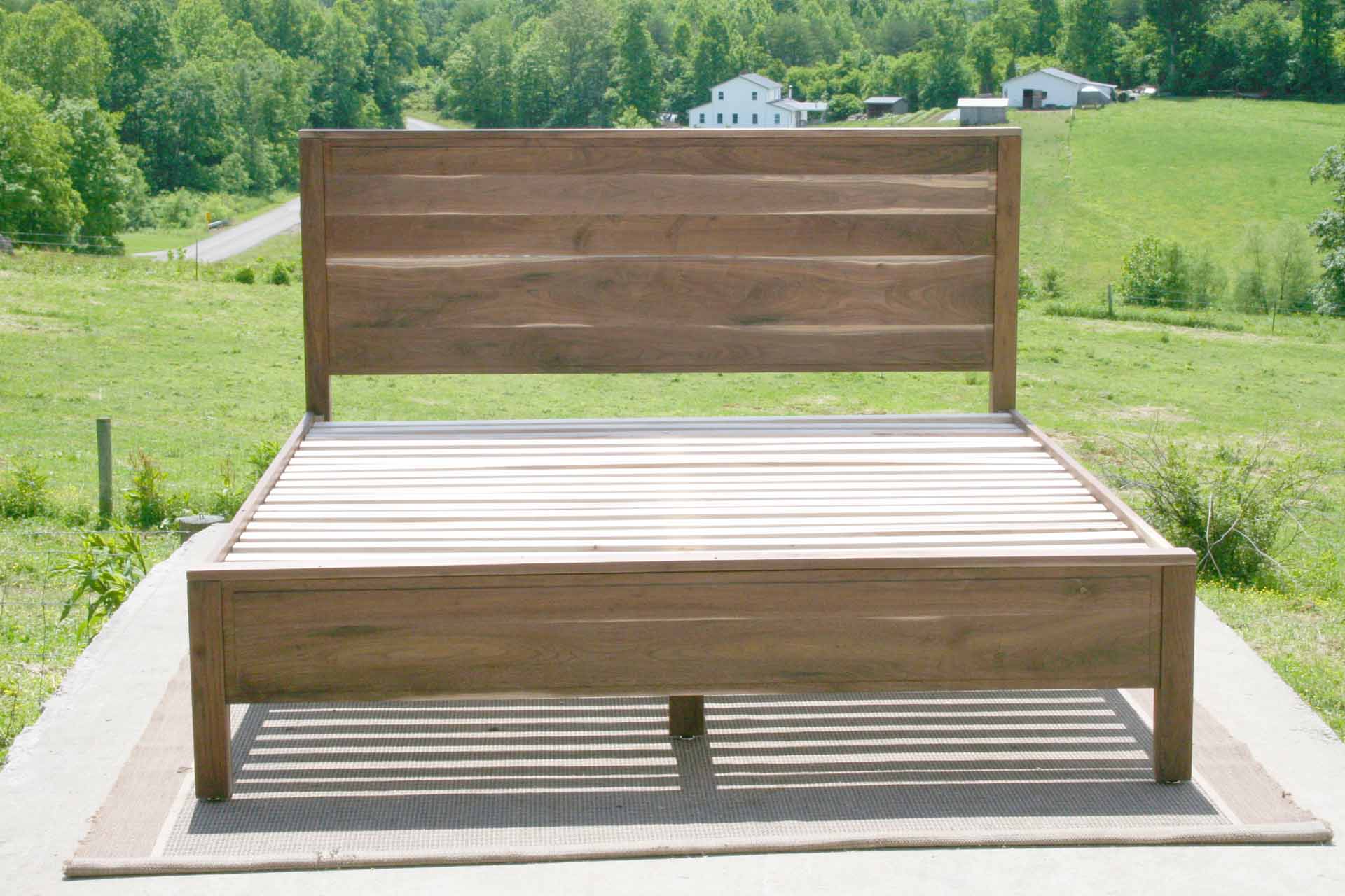 Paneled bed with platform and raised headboard straight on view