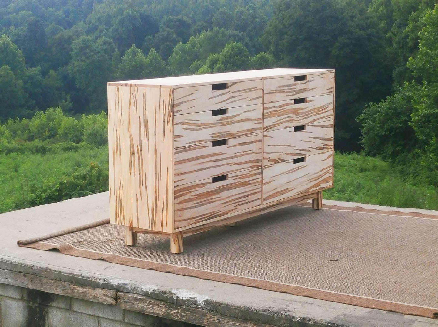 tall chest of drawers with 6 inset drawers cut out pulls and flat sides angled view