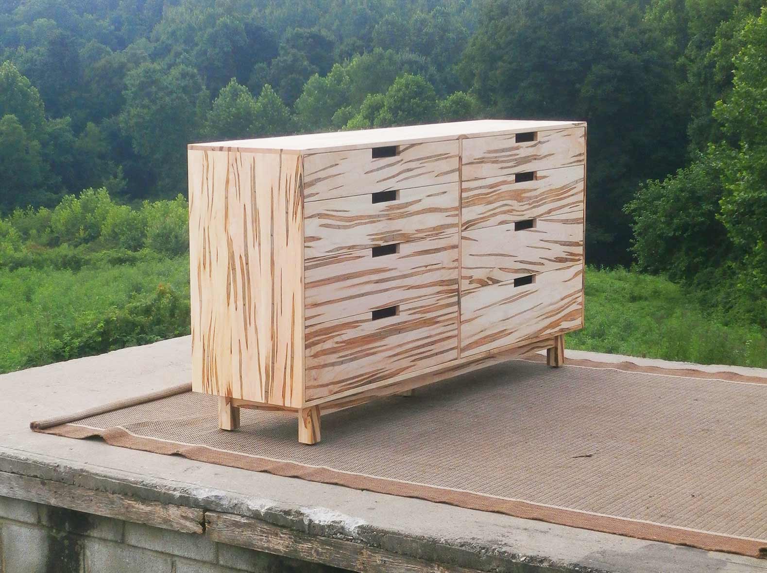 tall chest of drawers with 6 inset drawers cut out pulls and flat sides angled view